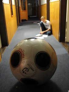 This student was taking a make-up history test from when he was sick. The large soccer ball in the foreground resides on the junior hall and is used as a chair, etc.