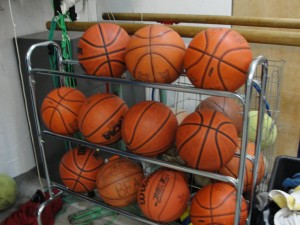 There is a lot of sports equipment in the weight room, including these basket balls